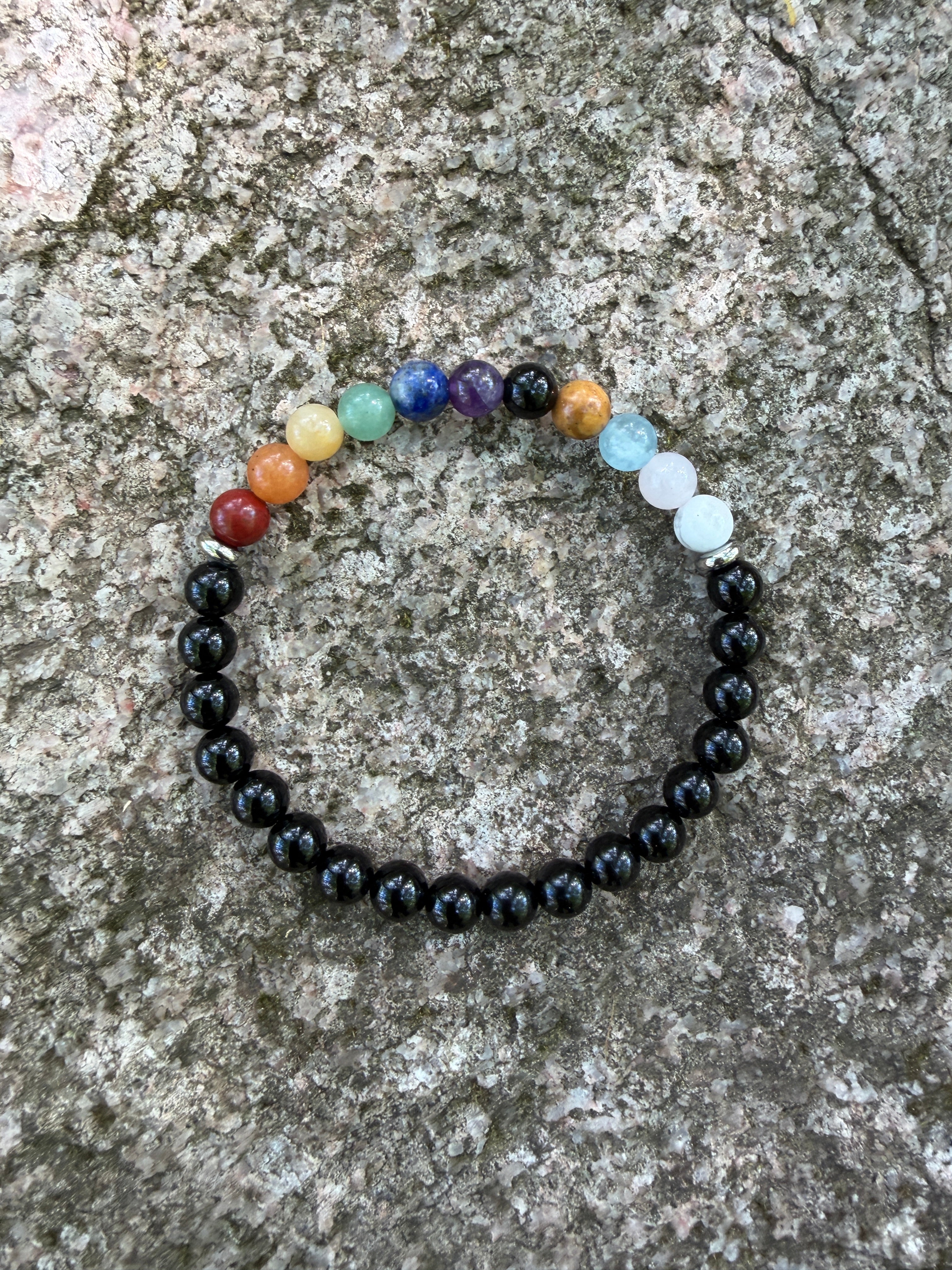 Multicolored beaded bracelet on a textured stone surface