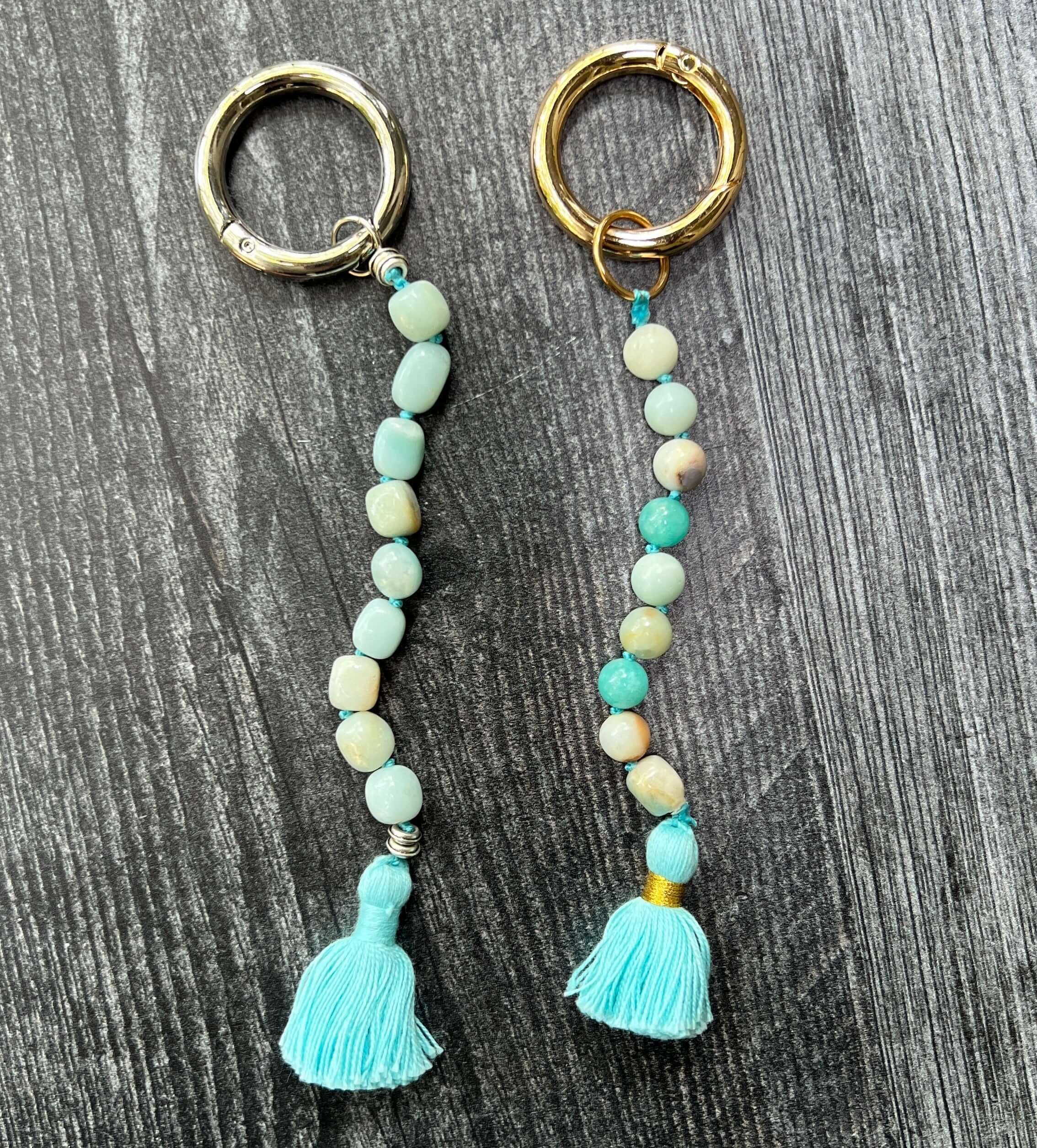 Pair of beaded keychains with tassels on a wooden surface