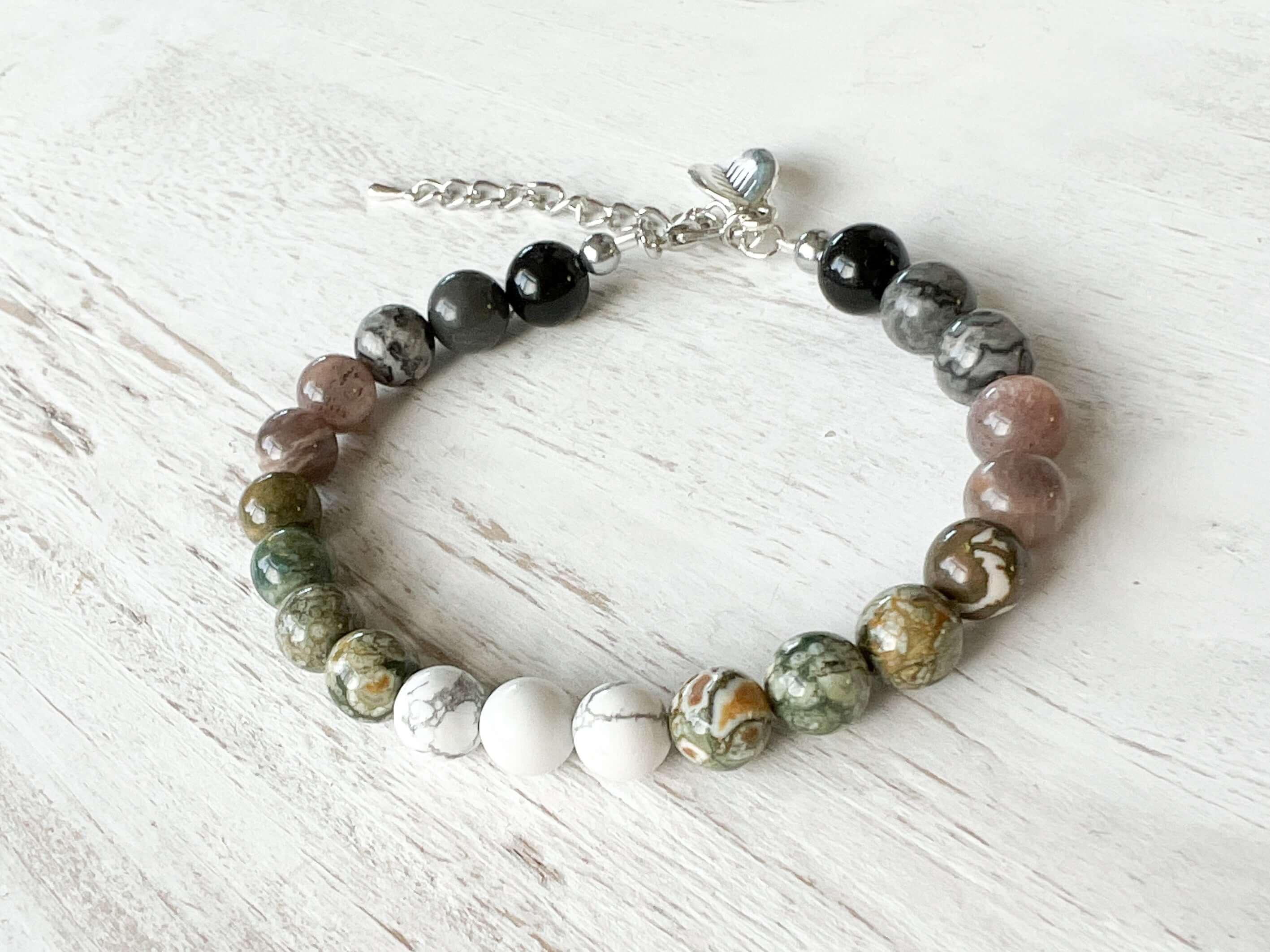 Earth Element Bracelet This bracelet is made with Black Obsidian, Gray Map Jasper, Gray Moonstone, Rhyolite, and Howlite to represent the Earth element. These stones offer a sense of tranquility, enhanced third eye visualization, and self-worth.