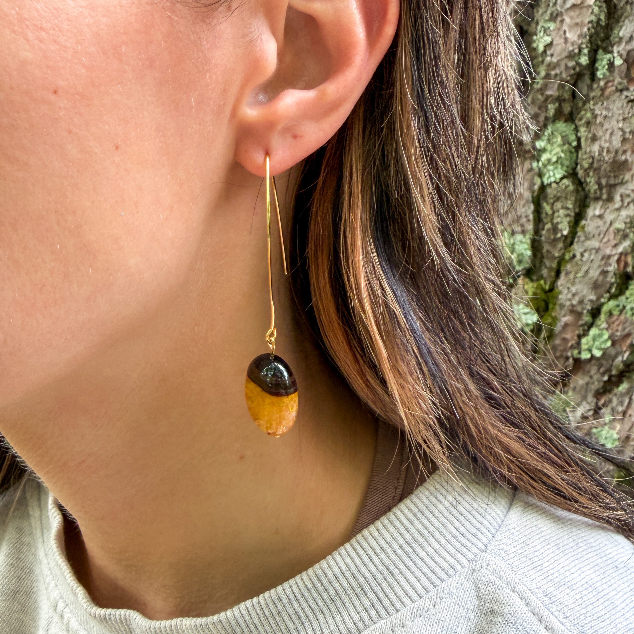 Natural Bumblebee Agate earrings with oval gemstones and elongated ear wires on model