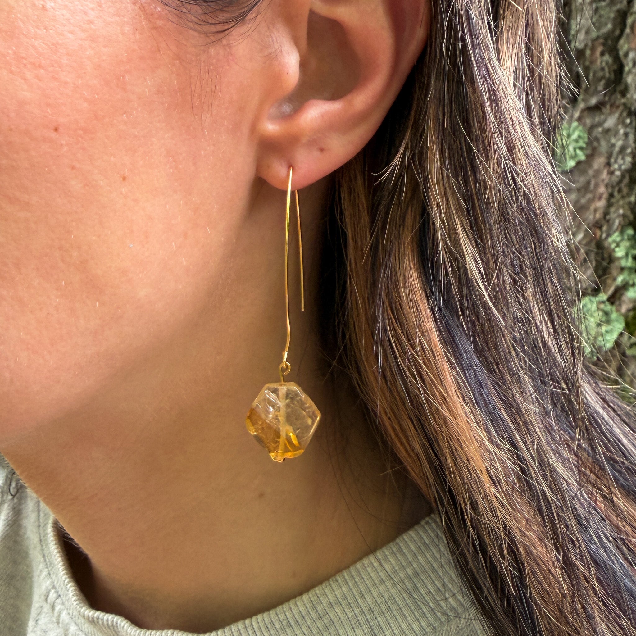 Natural Citrine gemstone earrings with hand-carved hexagon stones and gold-plated elongated ear wires on model