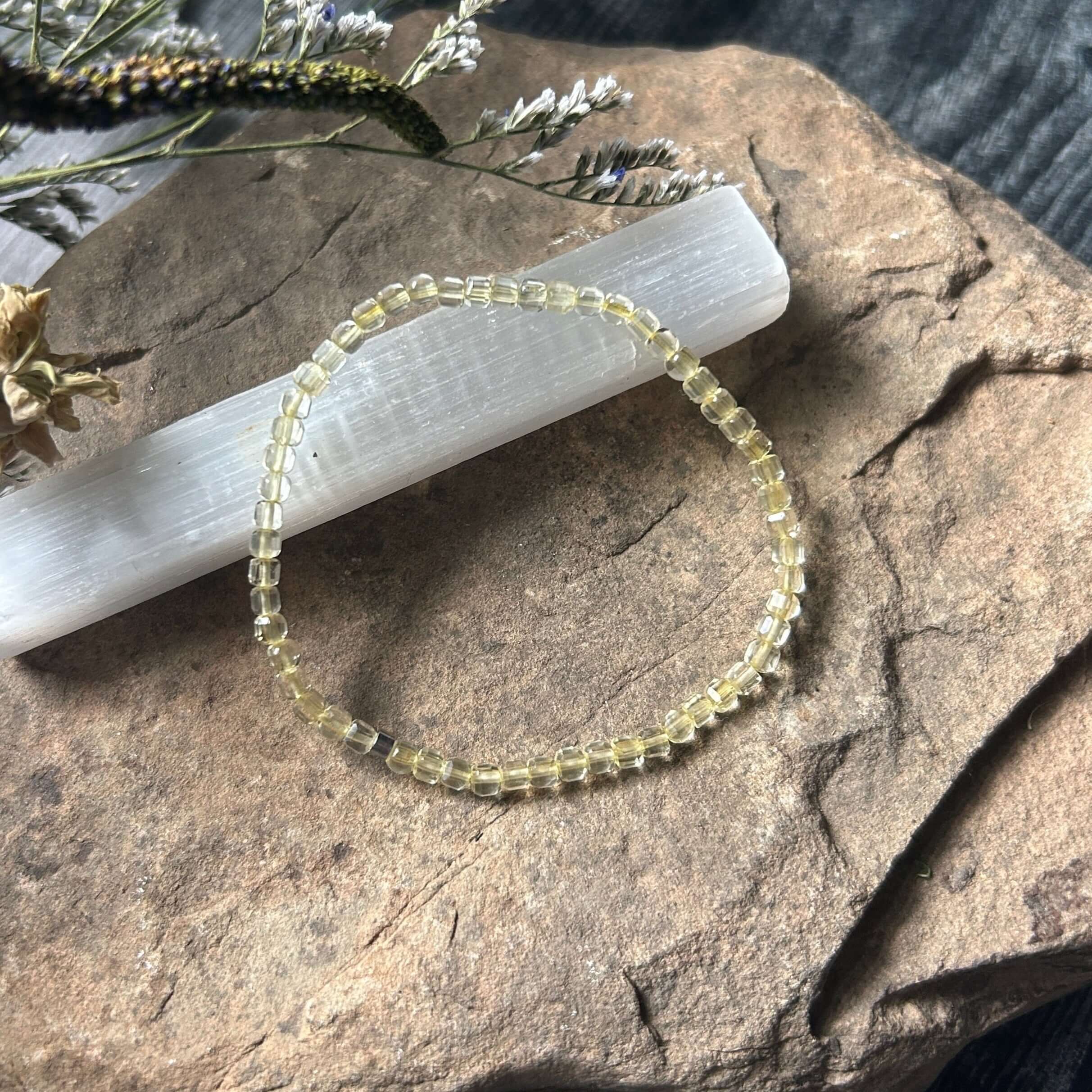 Citrine bracelet on a stone surface with dried plants