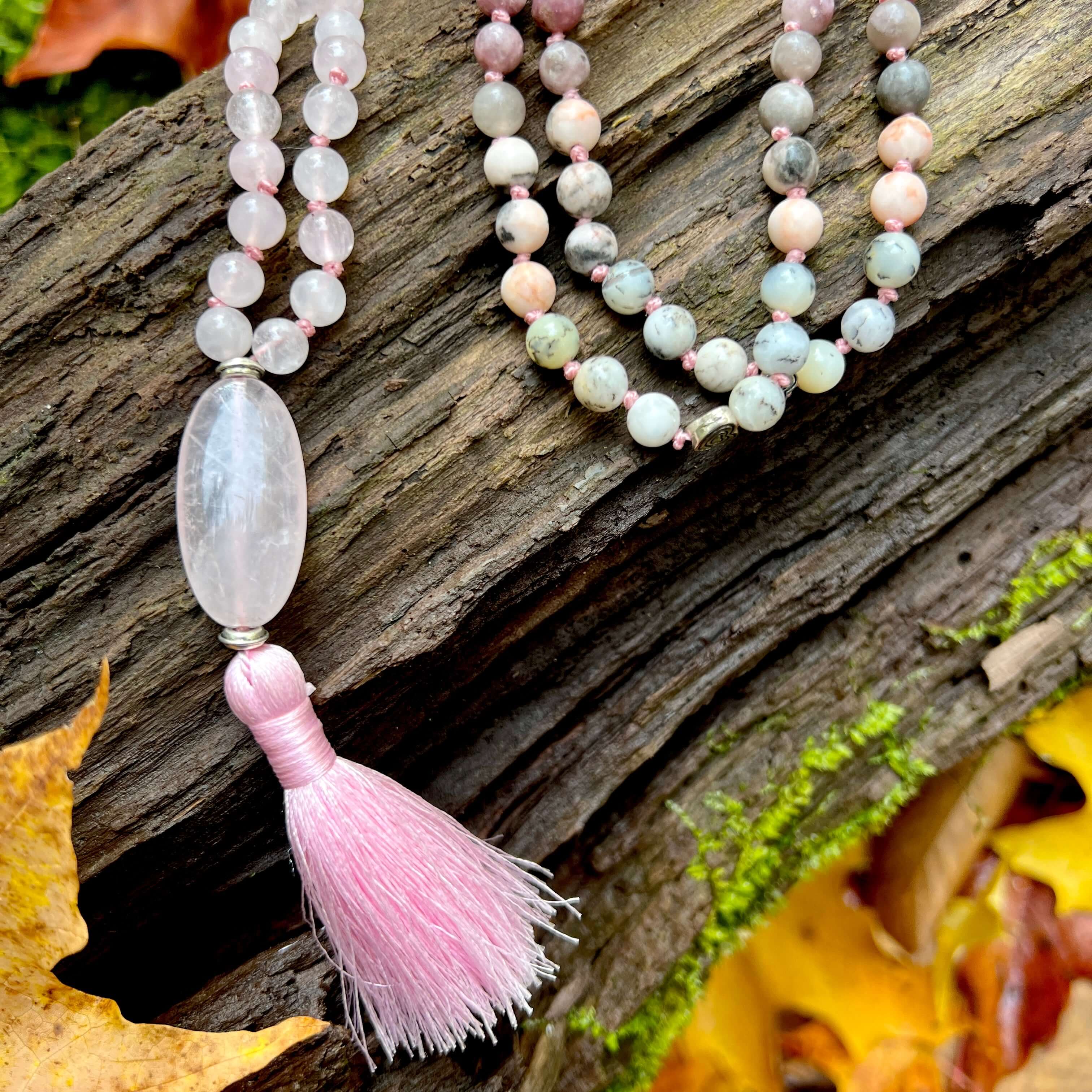 Loving Growth Mala Introducing our exquisite Loving Growth Mala Necklace crafted with high-quality Rose Quartz, Lepidolite, Pink Zebra Jasper, and Dendritic Opal. This beautifully designed mala is not just a piece of jewelry; it's a spiritual companion th