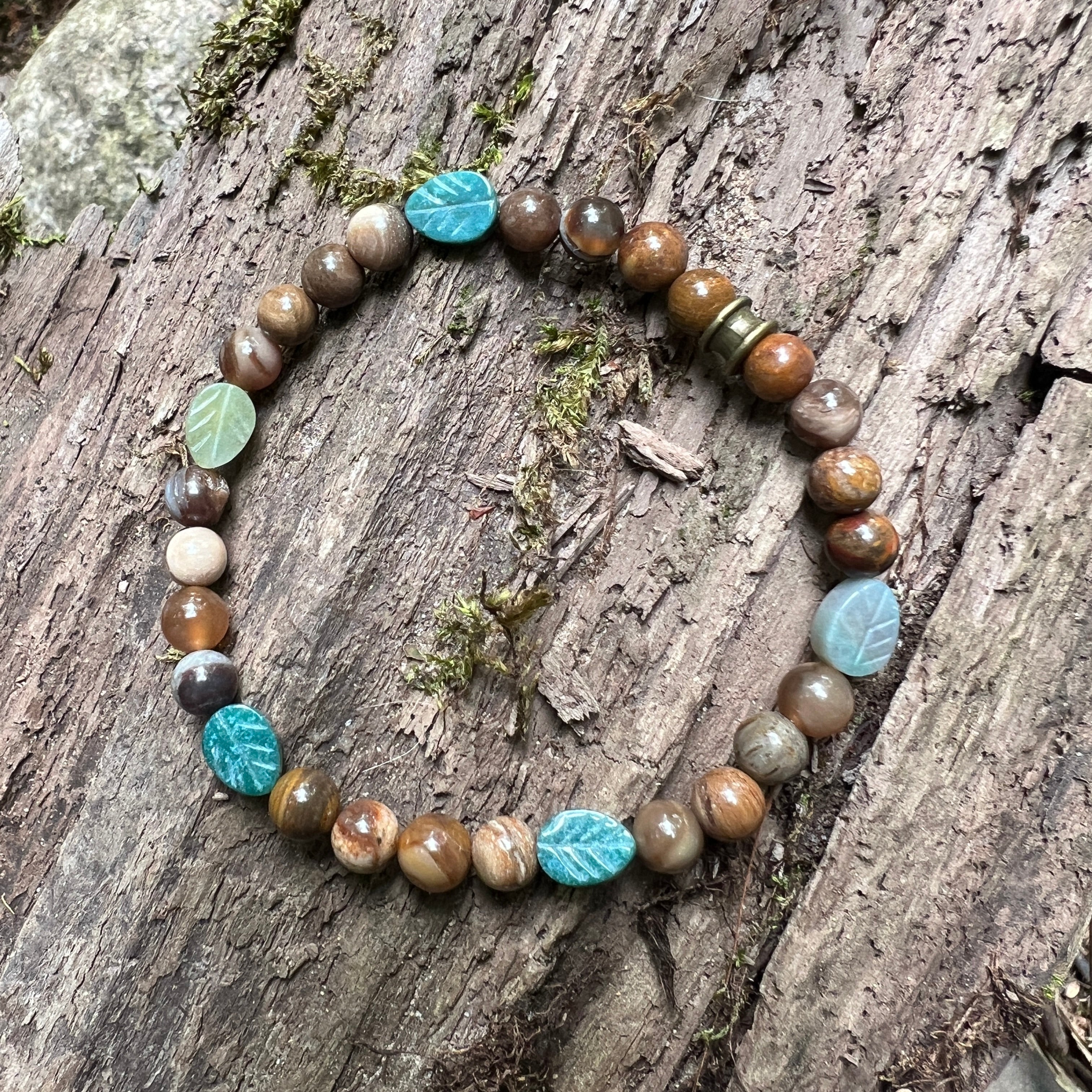 Bracelet with brown beads and agate leaf-shaped stones on a wooden surface