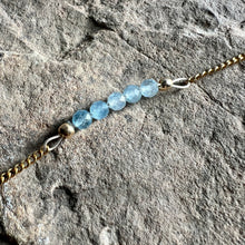 Load image into Gallery viewer, Close up of March birthstone bracelet made with faceted Aquamarine gemstones on gold chain.
