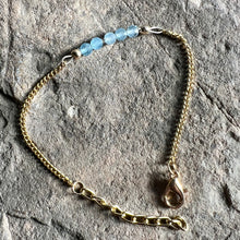 Load image into Gallery viewer, March birthstone bracelet made with faceted Aquamarine gemstones on gold chain.
