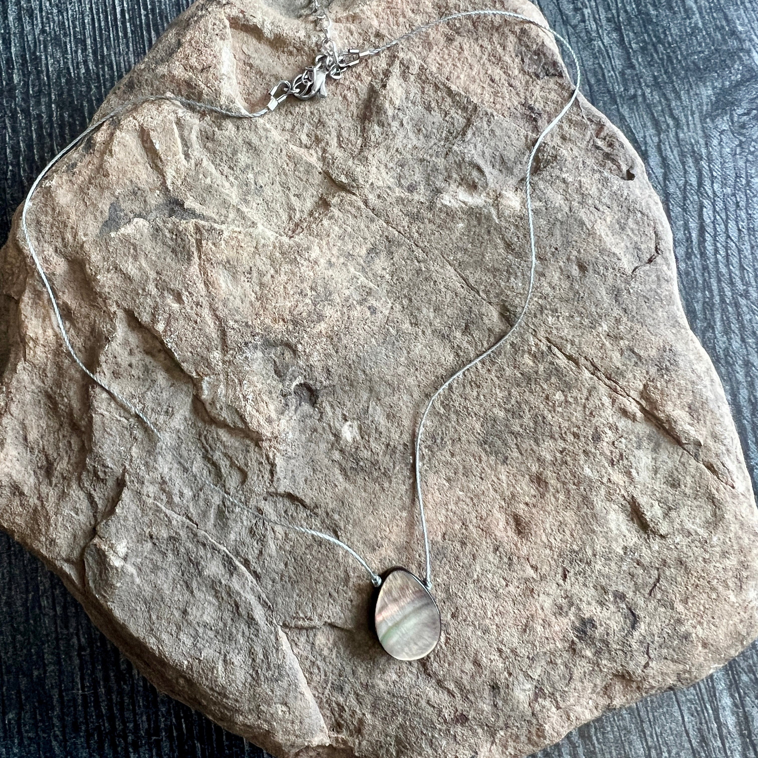 Necklace with a pendant on a stone surface