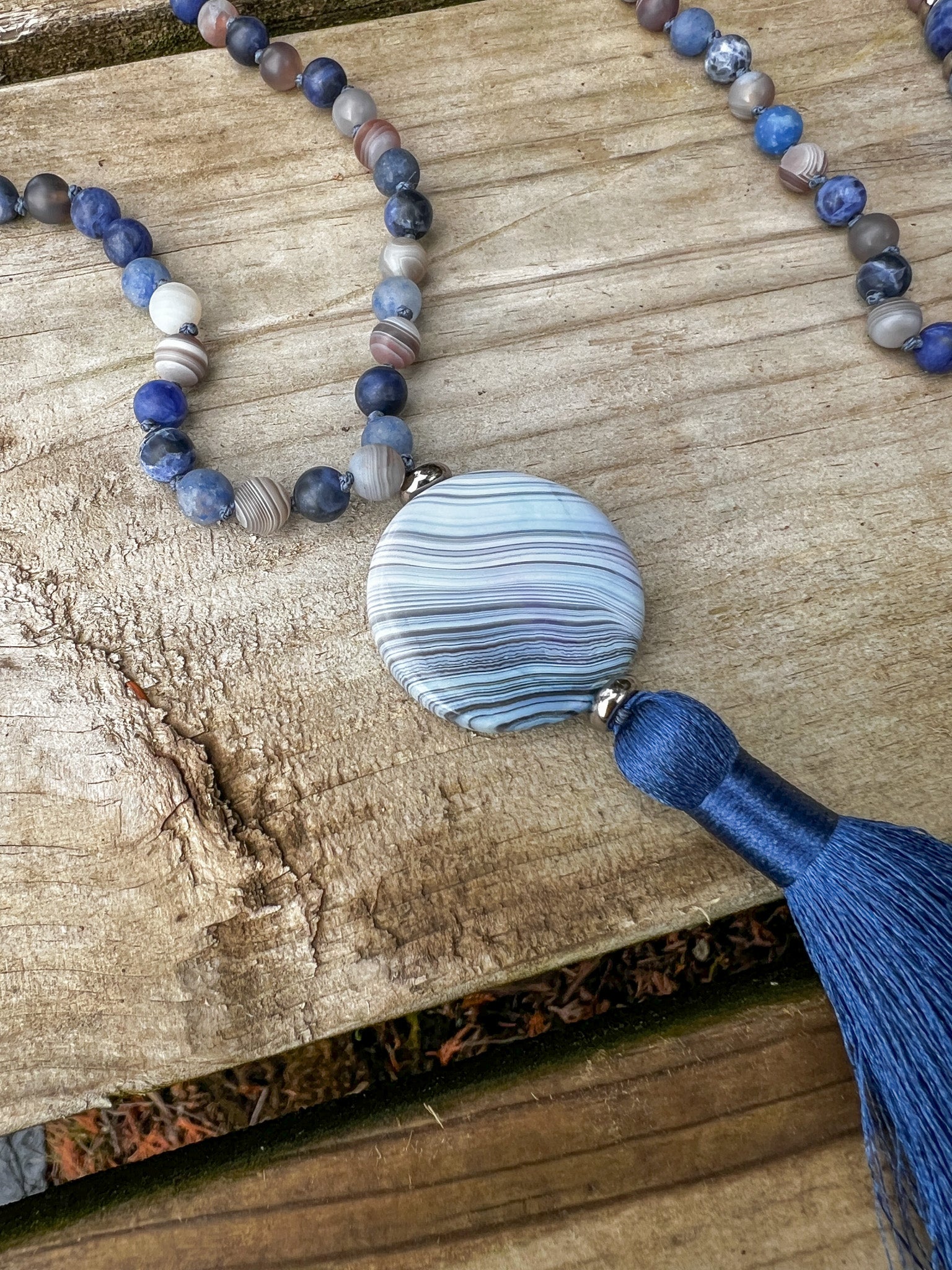 Blue agate focal stone with navy silk tassel on the handmade Ocean Current Mala Necklace.