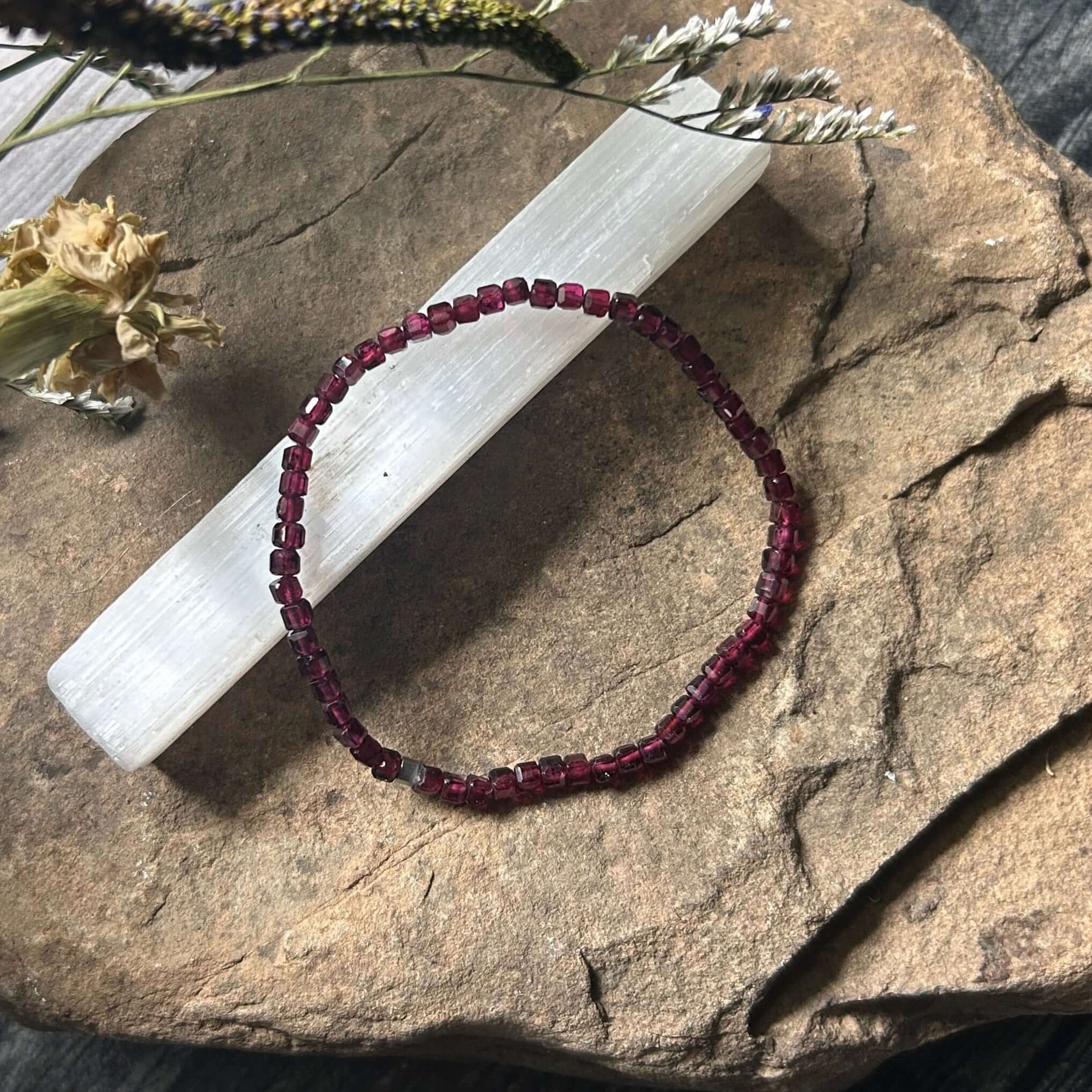 Purple Garnet beaded bracelet on a stone with dried plants