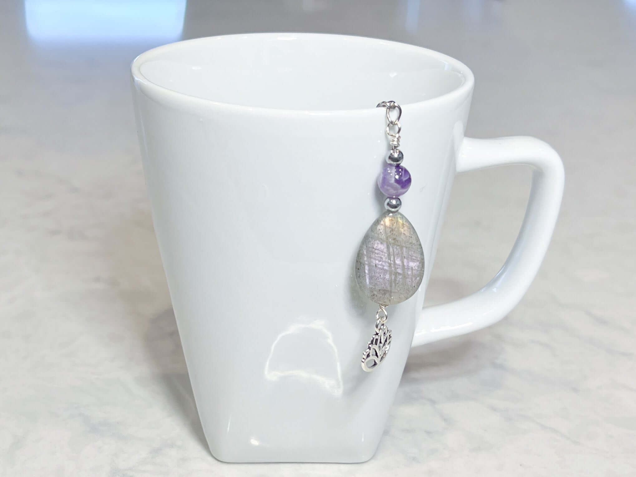 Amethyst and Labradorite Tea Strainer This tea strainer is made with a stainless steel tea ball, Chevron Amethyst, Labradorite, and Hematite beads. These stones offer clarity, transformation, and protection to the user.