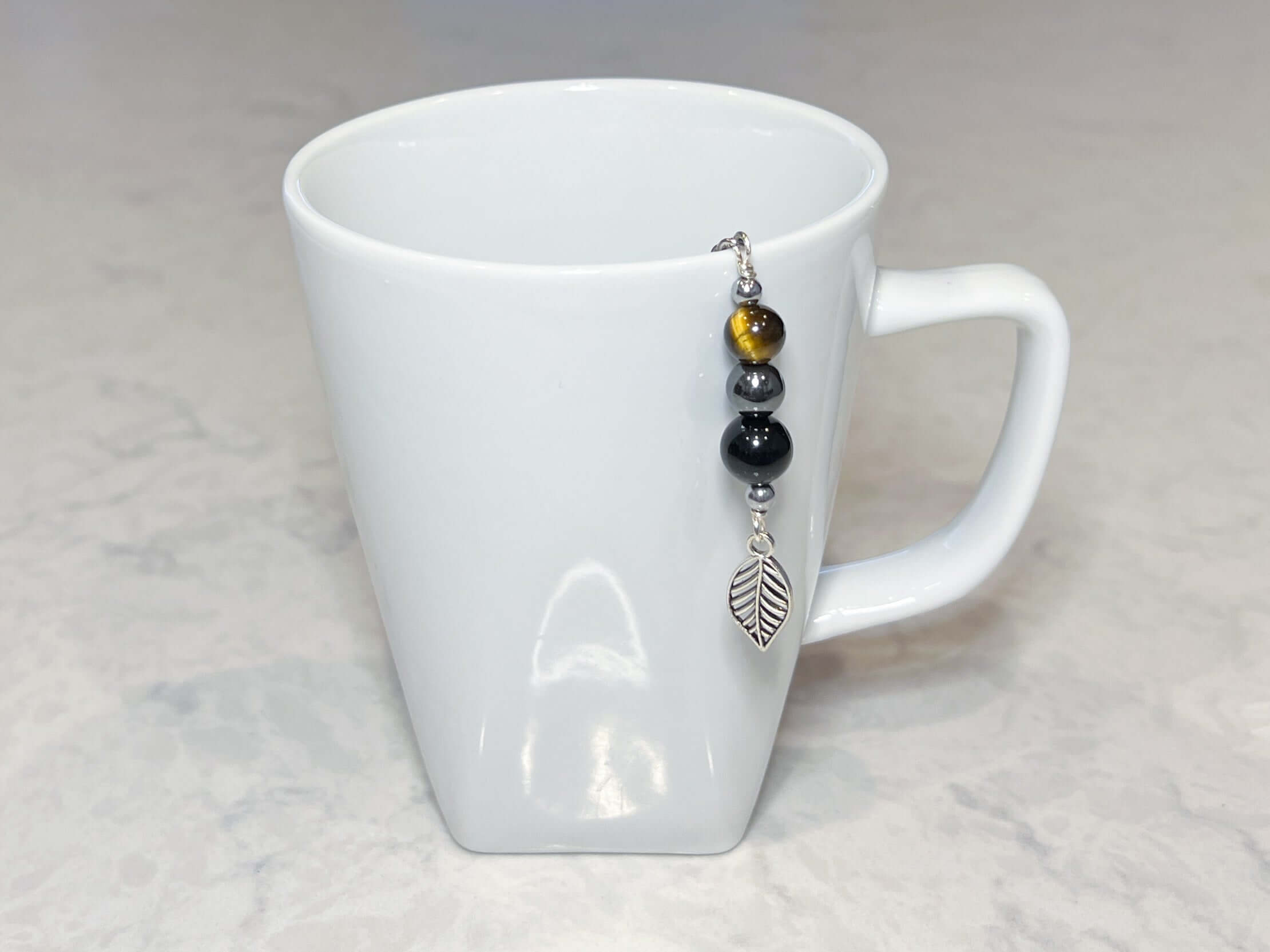 Triple Protection Tea Strainer This tea strainer is made with a stainless steel tea ball and gold sheen obsidian, hematite, and tiger eye. These stones offer protection against negative energy of all kinds- inner, spiritual, and environmental.