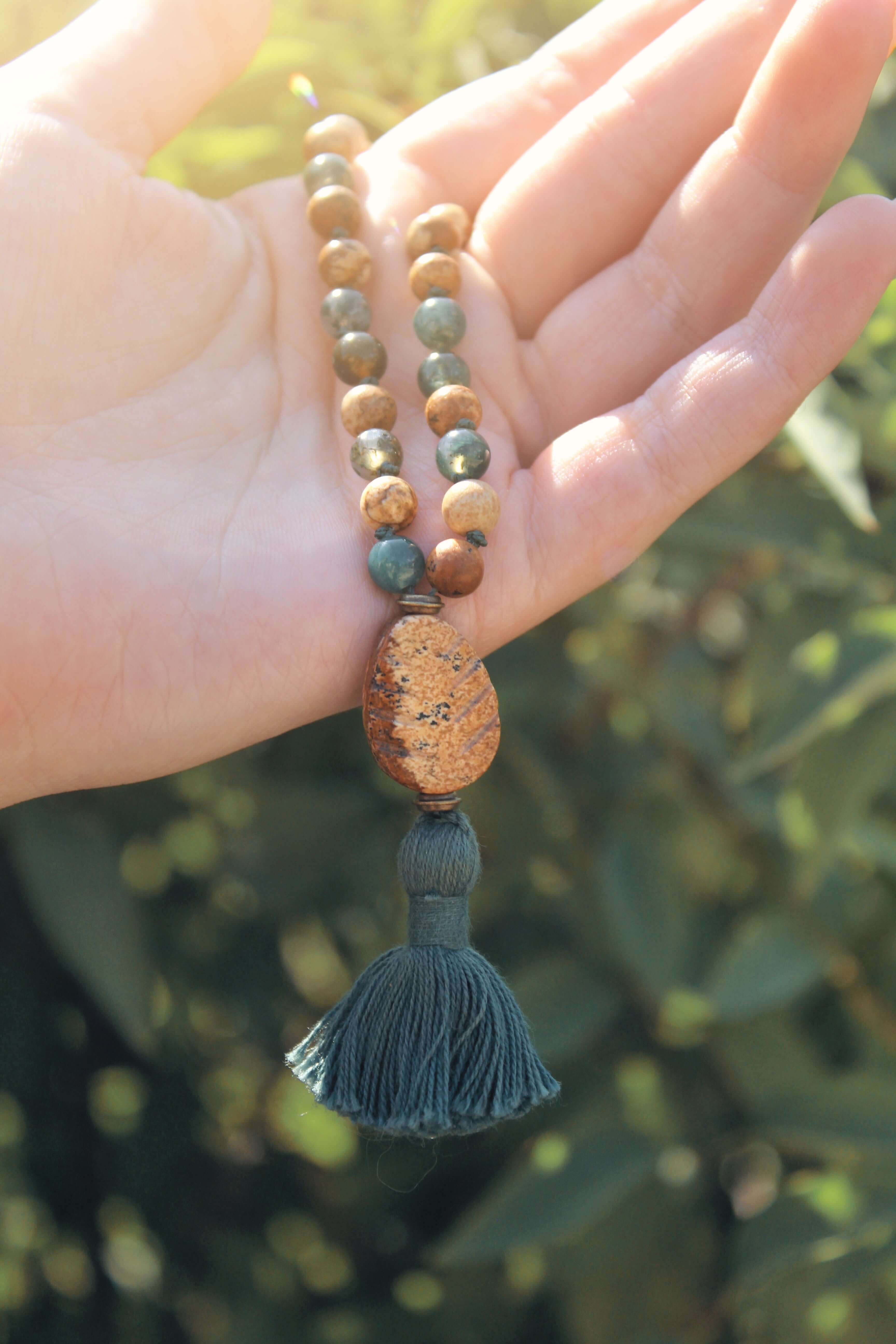 Pine Tree Quarter Mala This quarter mala is made with high-quality Picture Jasper and Moss Agate gemstones which bring confidence and abundance to the wearer. Zodiac Signs: Leo, Capricorn, & Virgo. Chakras: Root, Third Eye, & Heart. Handmade with authenti