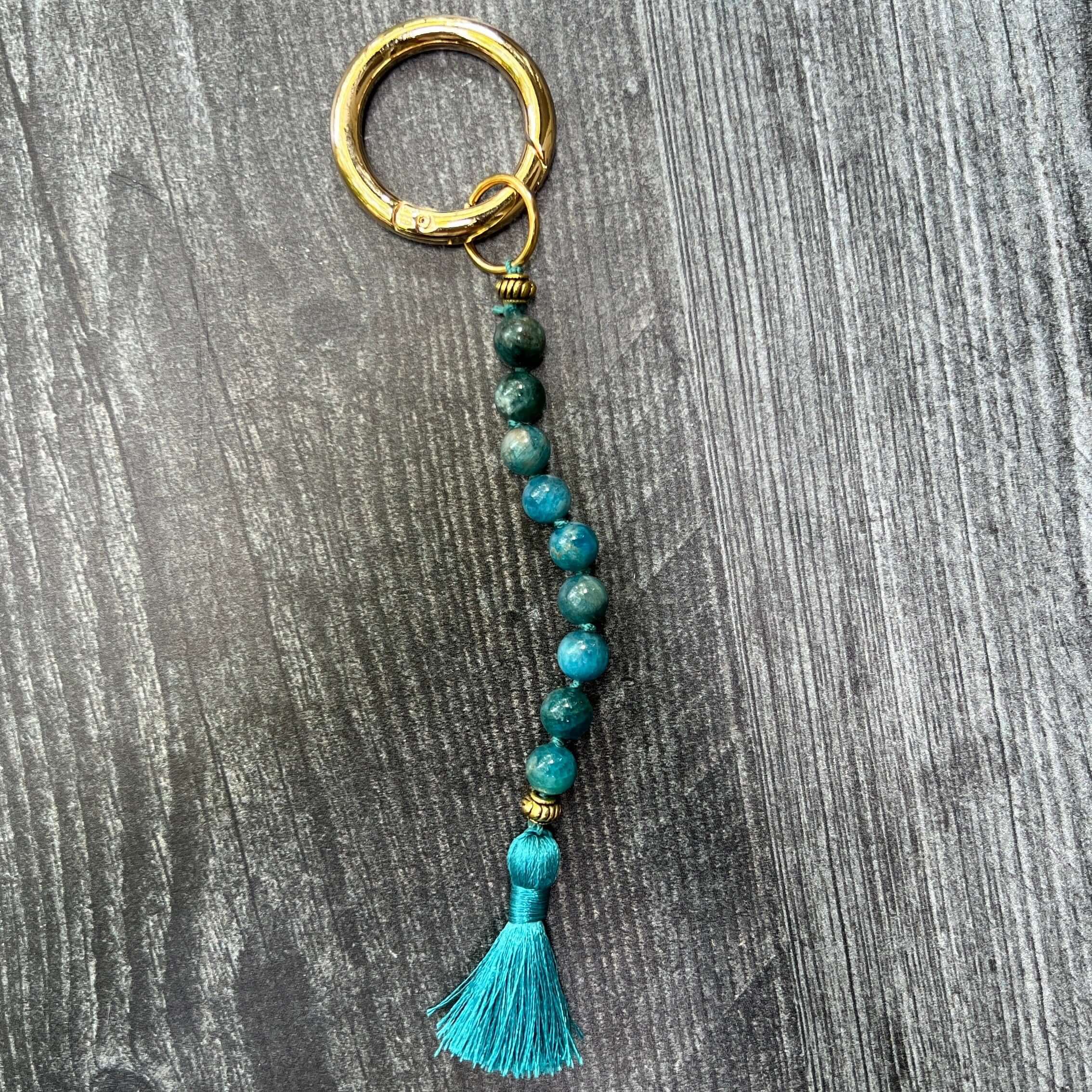 Keychain with beads and tassel on a wooden surface