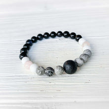 Load image into Gallery viewer, Lava Stone Focal Bracelet with Rainbow Obsidian This bracelet is made with a Lava stone focal bead, Gray Map Jasper, White Jade, Pink Morganite, and Rainbow Obsidian. Together these stones bring the wearer a sense of relaxation, and a release of stagnant
