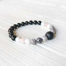 Load image into Gallery viewer, Lava Stone Focal Bracelet with Rainbow Obsidian This bracelet is made with a Lava stone focal bead, Gray Map Jasper, White Jade, Pink Morganite, and Rainbow Obsidian. Together these stones bring the wearer a sense of relaxation, and a release of stagnant
