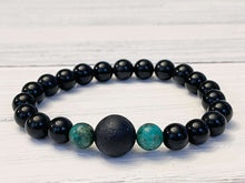 Load image into Gallery viewer, Lava Stone Focal Bracelet with African Turquoise This bracelet is made with a Lava stone focal bead, African Turquoise, and Rainbow Obsidian. These stones together bring light to the most blocked and stagnant energy and give the wearer strength to pursue
