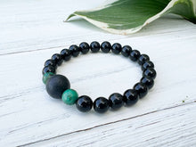 Load image into Gallery viewer, Lava Stone Focal Bracelet with African Turquoise This bracelet is made with a Lava stone focal bead, African Turquoise, and Rainbow Obsidian. These stones together bring light to the most blocked and stagnant energy and give the wearer strength to pursue
