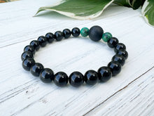 Load image into Gallery viewer, Lava Stone Focal Bracelet with African Turquoise This bracelet is made with a Lava stone focal bead, African Turquoise, and Rainbow Obsidian. These stones together bring light to the most blocked and stagnant energy and give the wearer strength to pursue
