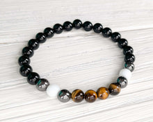 Load image into Gallery viewer, Triple Protection Obsidian, Tiger Eye, and Hematite Bracelet This bracelet is made with Black Obsidian, Tiger Eye, and Hematite. These stones together brings the wearer protection against negative energy of all kinds- inner, spiritual, and environmental.
