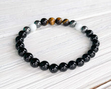 Load image into Gallery viewer, Triple Protection Obsidian, Tiger Eye, and Hematite Bracelet This bracelet is made with Black Obsidian, Tiger Eye, and Hematite. These stones together brings the wearer protection against negative energy of all kinds- inner, spiritual, and environmental.
