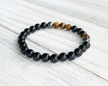 Load image into Gallery viewer, Triple Protection Obsidian, Tiger Eye, and Hematite Bracelet This bracelet is made with Black Obsidian, Tiger Eye, and Hematite. These stones together brings the wearer protection against negative energy of all kinds- inner, spiritual, and environmental.
