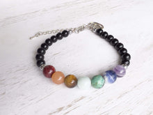 Load image into Gallery viewer, Obsidian Chakra Bracelet This bracelet is made with black obsidian, and chakra stones with a lotus charm. These stones together help the wearer balance the energy of their chakras. Stones include Jasper, Aventurine, Moonstone, Turquoise, Sodalite, Amethys
