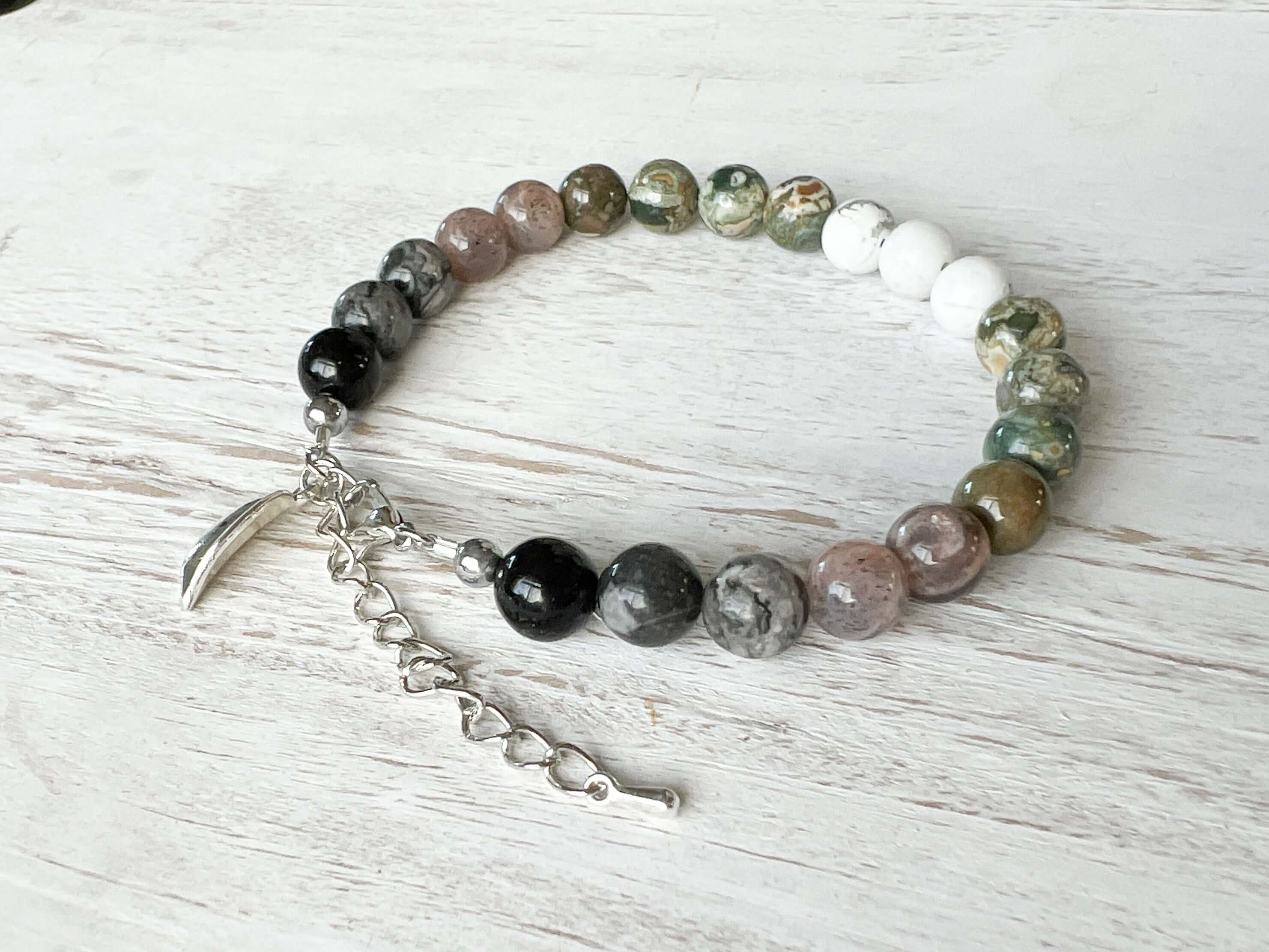 Earth Element Bracelet This bracelet is made with Black Obsidian, Gray Map Jasper, Gray Moonstone, Rhyolite, and Howlite to represent the Earth element. These stones offer a sense of tranquility, enhanced third eye visualization, and self-worth.