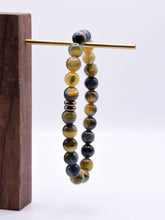 Load image into Gallery viewer, Blue and Blonde Tiger Eye Bead Bracelet This bracelet is made with high-quality Blue and Blonde Tiger Eye stones which bring confidence and optimism to the wearer. Zodiac Signs: Leo and Capricorn. Chakras: Root and Solar Plexus. Handmade with authentic cr
