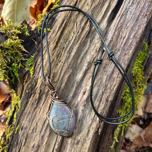 Purple Labradorite Wire Wrapped Pendant This pendant is made with purple flash Labradorite and solid copper wire that has a patina for an antiqued look. Labradorite is known as the stone of transformation and enhances the wearers will strength and sense o