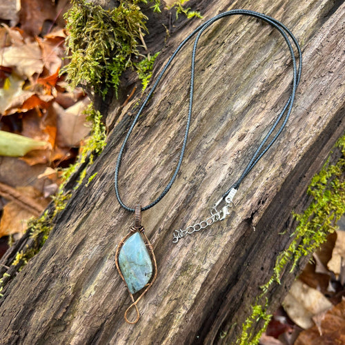 Labradorite Wire Wrapped Pendant This pendant is made with rainbow flash Labradorite and solid copper wire that has a patina for an antiqued look. Labradorite is known as the stone of transformation and enhances the wearers will strength and sense of inne