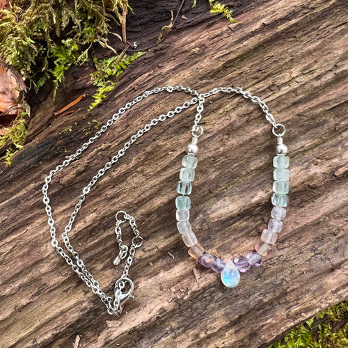Fluorite and Moonstone Necklace This beaded necklace is made with rainbow fluorite and a rainbow moonstone briolette. Fluorite and moonstone bring the wearer cleansing energy and enhanced intuition.