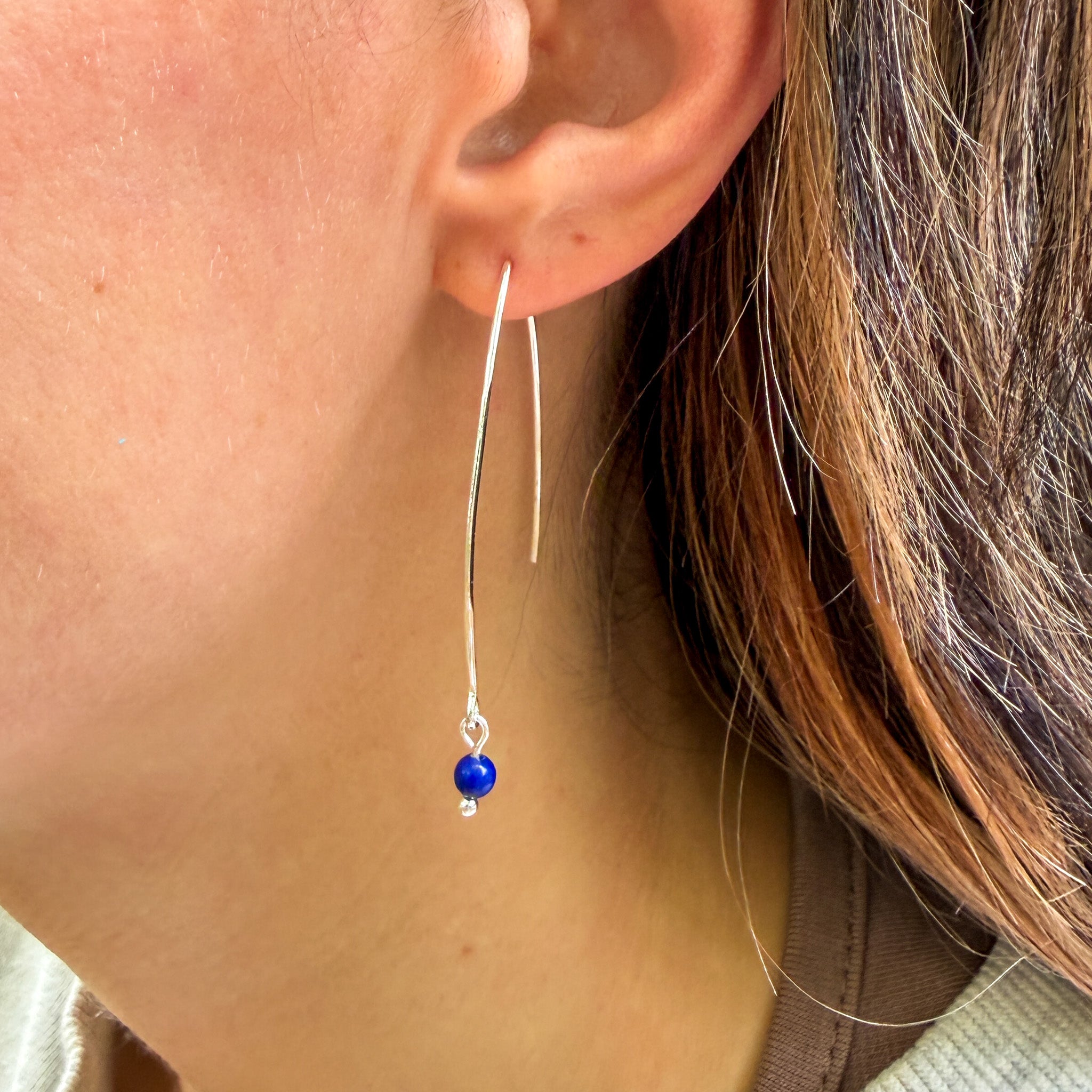 Handcrafted Lapis Lazuli earrings with natural 4mm gemstones on stainless steel elongated ear wires on model