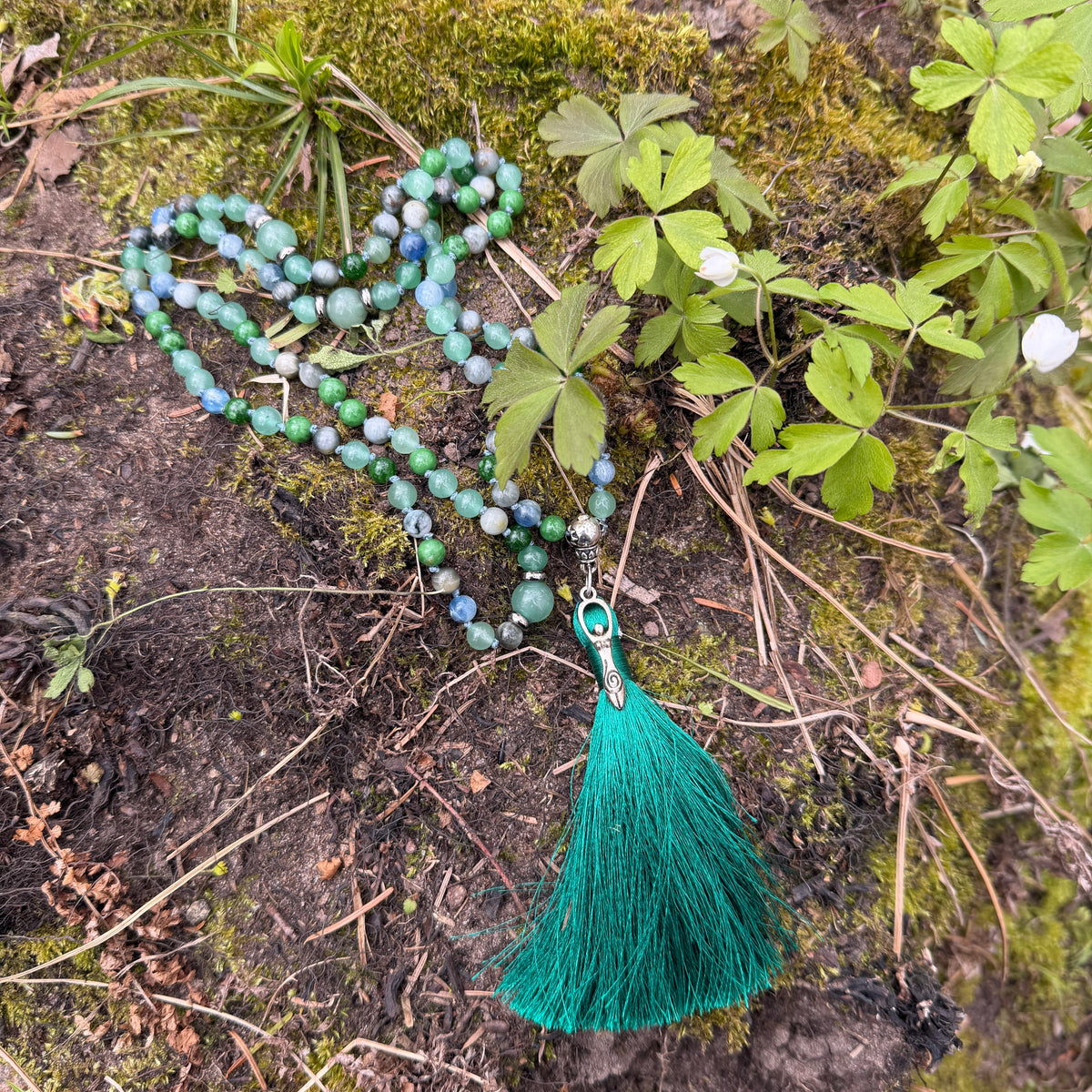 Green beaded necklace with tassel on a natural background