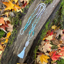 Load image into Gallery viewer, Crown Chakra Mala The Crown Chakra Mala is designed to awaken your spiritual consciousness and unlock your connection to the Divine. Handmade with multiple forms of Quartz, along with Aquamarine, and Green Fluorite, the Crown Chakra Mala provides healing
