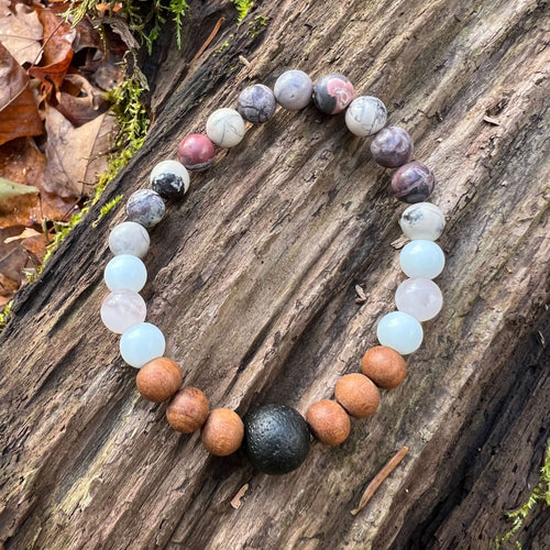 Lava Stone Focal Bracelet with Sandalwood This bracelet is made with a Lava focal bead, Sandalwood, White Jade, pink Morganite, and Porcelain Jasper. Together these stones work together to bring the wearer a sense of tranquility, love, and abundance.