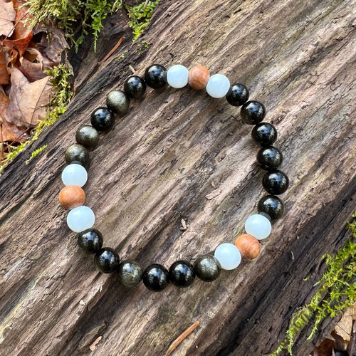 Golden Obsidian, Sandalwood, and White Jade Bracelet This bracelet is made with high quality Golden Obsidian, aromatic Sandalwood, and White Jade. Golden Obsidian and Sandalwood dissolves negativity, purifies the aura, and heals the solar plexus chakra wh