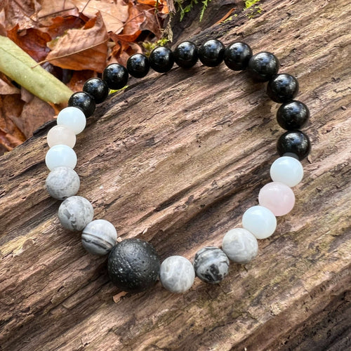 Lava Stone Focal Bracelet with Rainbow Obsidian This bracelet is made with a Lava stone focal bead, Gray Map Jasper, White Jade, Pink Morganite, and Rainbow Obsidian. Together these stones bring the wearer a sense of relaxation, and a release of stagnant