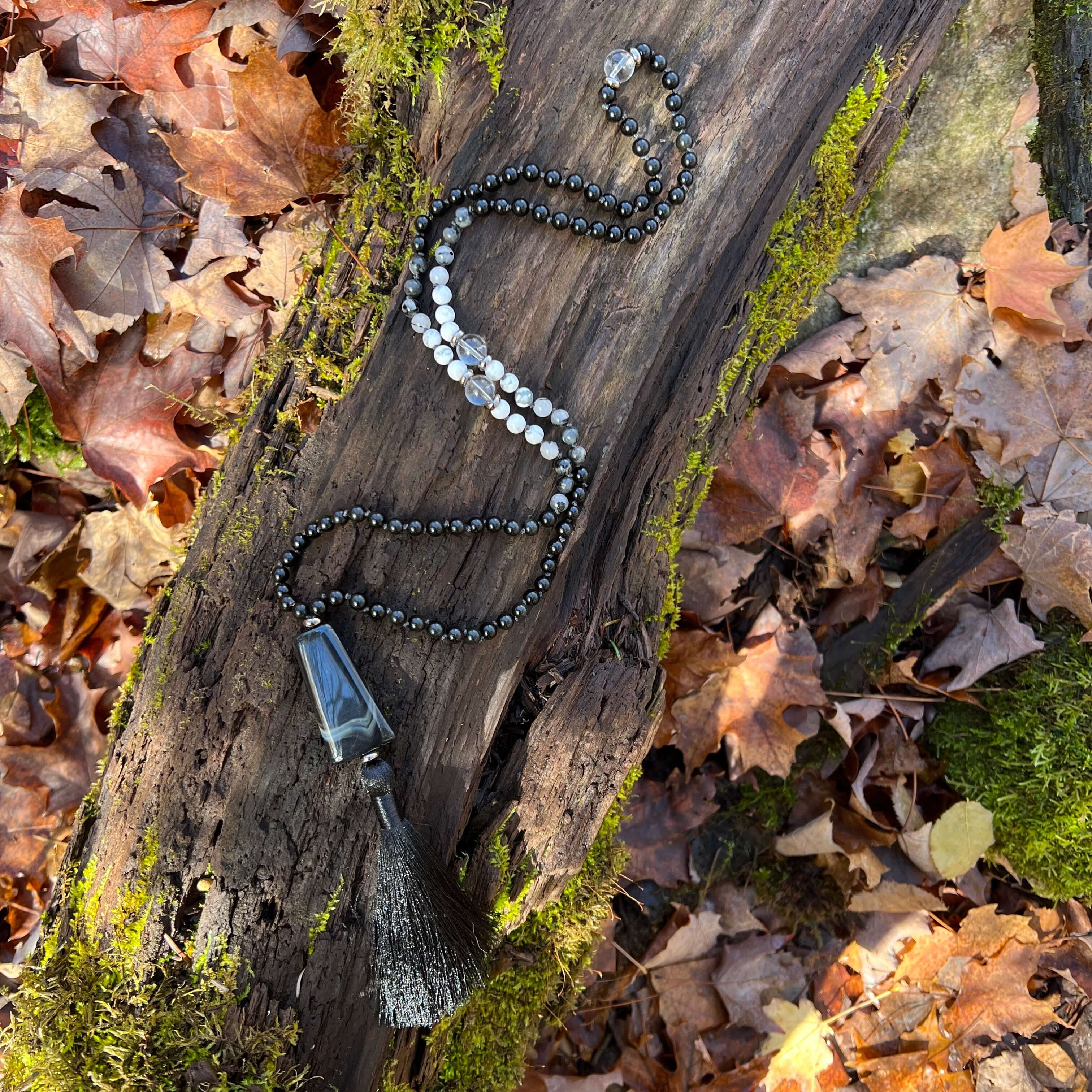 Light in the Darkness Mala Necklace Embrace your serene power within the Light in the Darkness Mala necklace. A handcrafted piece that harmonizes the ancient wisdom of gemstones with contemporary mindfulness. As you wear this hand-knotted treasure, you'll