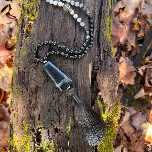 Light in the Darkness Mala Necklace Embrace your serene power within the Light in the Darkness Mala necklace. A handcrafted piece that harmonizes the ancient wisdom of gemstones with contemporary mindfulness. As you wear this hand-knotted treasure, you'll
