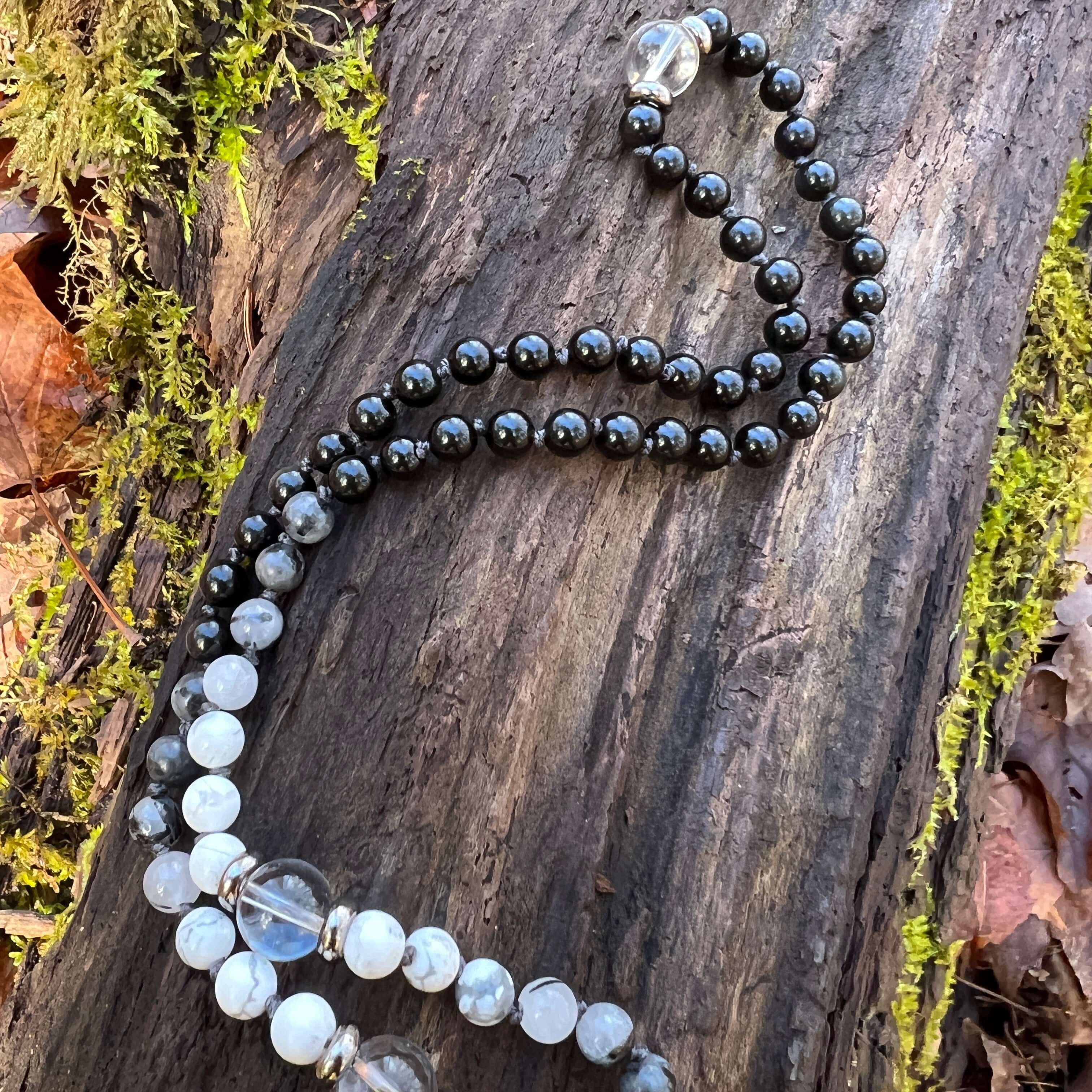 Light in the Darkness Mala Necklace Embrace your serene power within the Light in the Darkness Mala necklace. A handcrafted piece that harmonizes the ancient wisdom of gemstones with contemporary mindfulness. As you wear this hand-knotted treasure, you'll