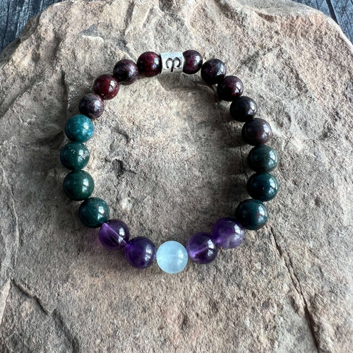 Aries Zodiac Bracelet The Aries Zodiac Bracelet is created with a combination of Aquamarine, Amethyst, Bloodstone, and Garnet beads, which resonate with the passionate, courageous qualities associated with this zodiac sign.