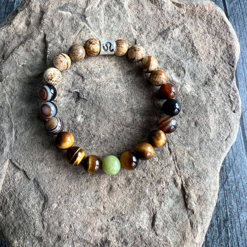 Leo Zodiac Bracelet The Leo Zodiac Bracelet is created with a combination of Peridot, Tiger Eye, and Picture Jasper beads which resonate with the bold and charismatic qualities associated with this zodiac sign.