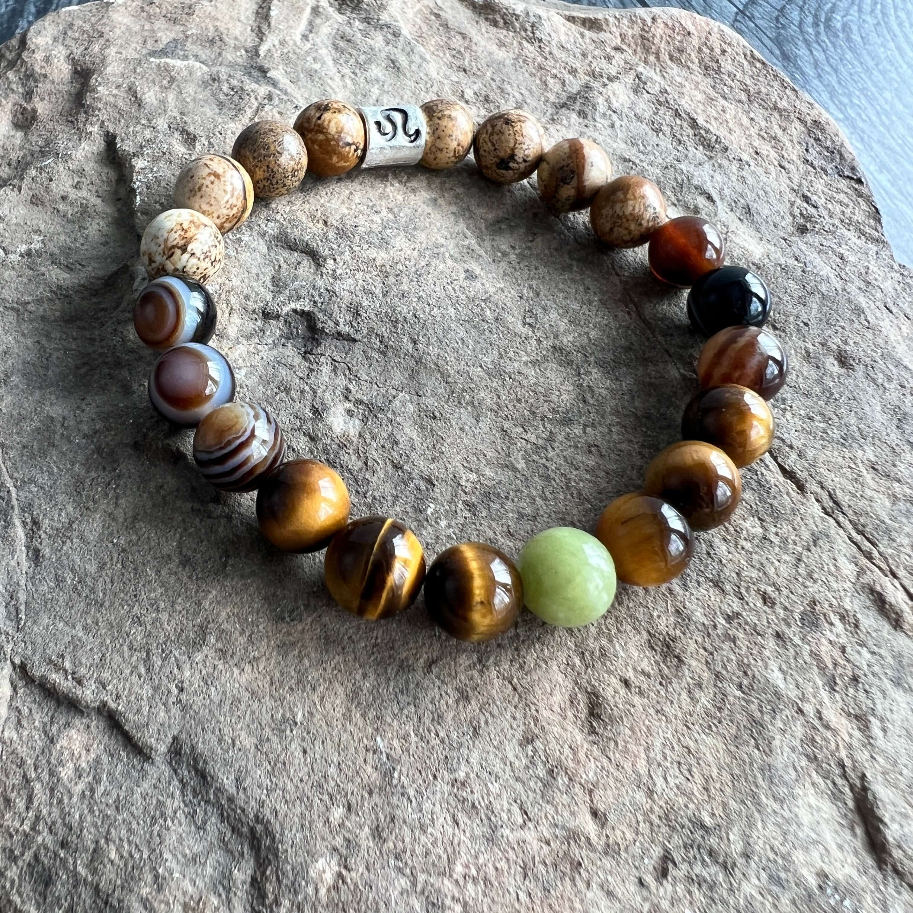 Leo Zodiac Bracelet The Leo Zodiac Bracelet is created with a combination of Peridot, Tiger Eye, and Picture Jasper beads which resonate with the bold and charismatic qualities associated with this zodiac sign.