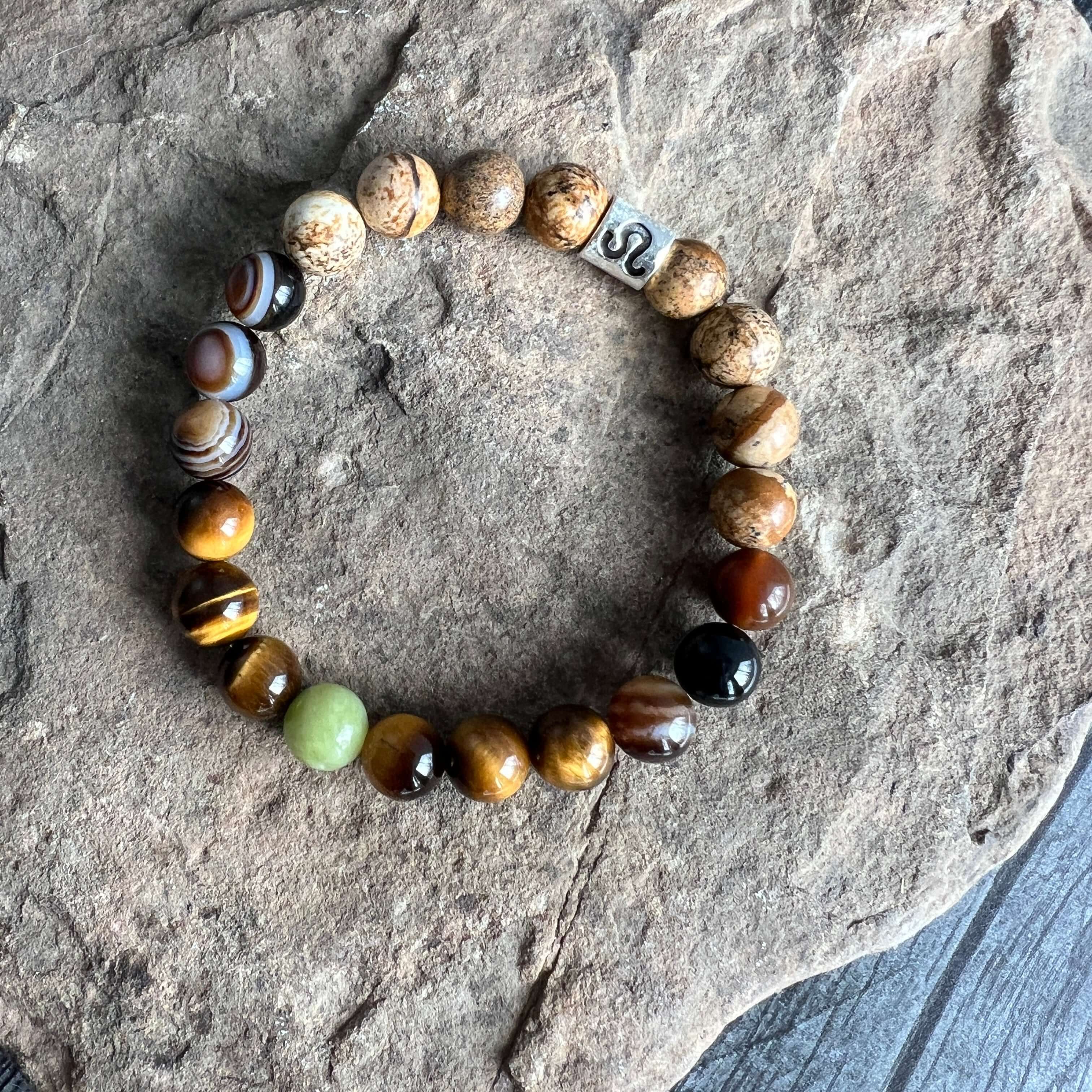 Leo Zodiac Bracelet The Leo Zodiac Bracelet is created with a combination of Peridot, Tiger Eye, and Picture Jasper beads which resonate with the bold and charismatic qualities associated with this zodiac sign.