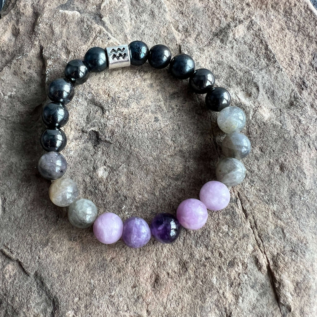 Aquarius Zodiac Bracelet The Aquarius Zodiac Bracelet is created with a combination of Amethyst, Lepidolite, Hematite, and Labradorite beads, which resonate with the versatile and expressive qualities associated with this zodiac sign.