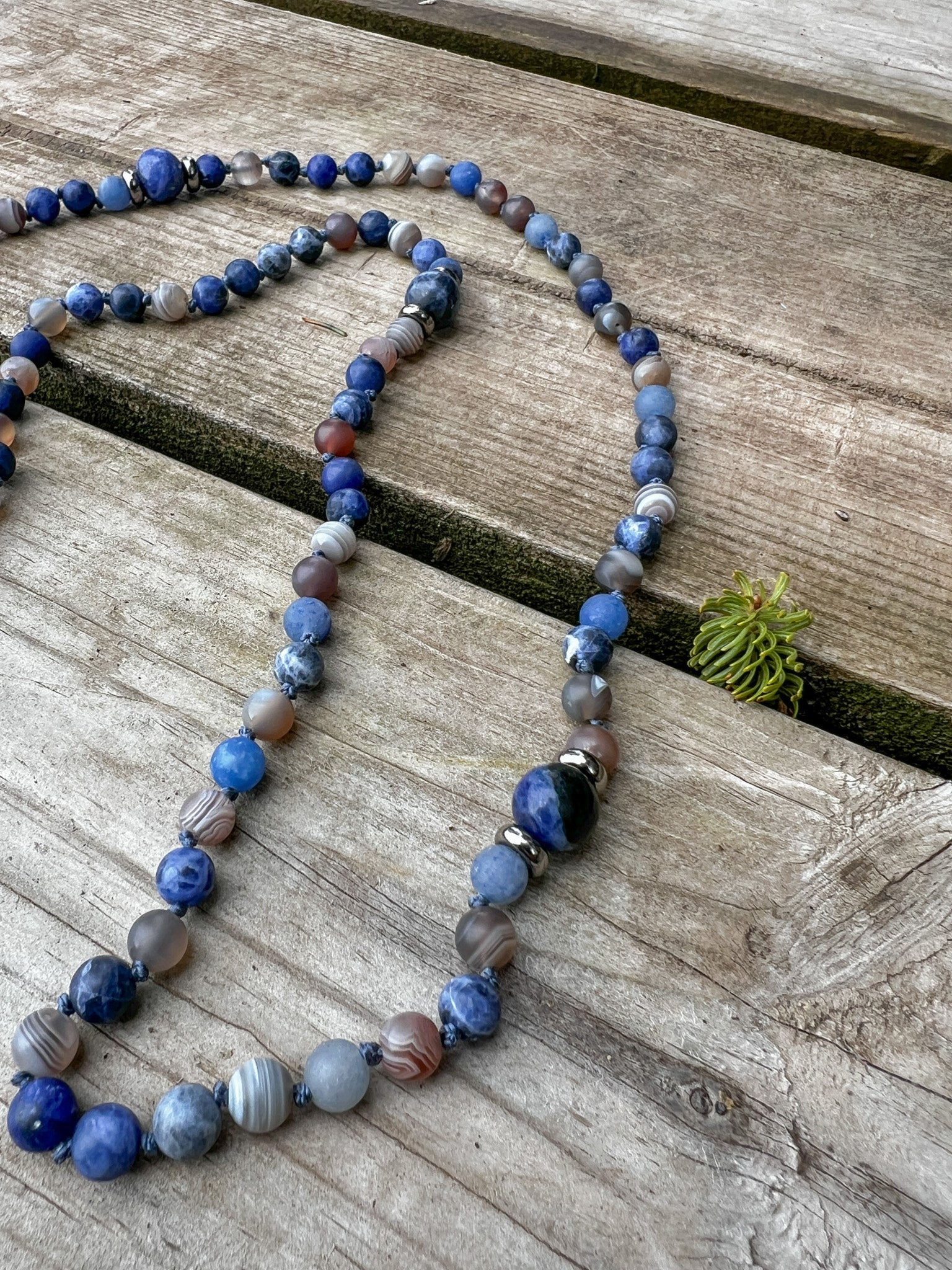 Close-up of the Ocean Current Mala Necklace highlighting hand-knotted Blue Aventurine, Sodalite, Botswana Agate, and stainless steel accents.