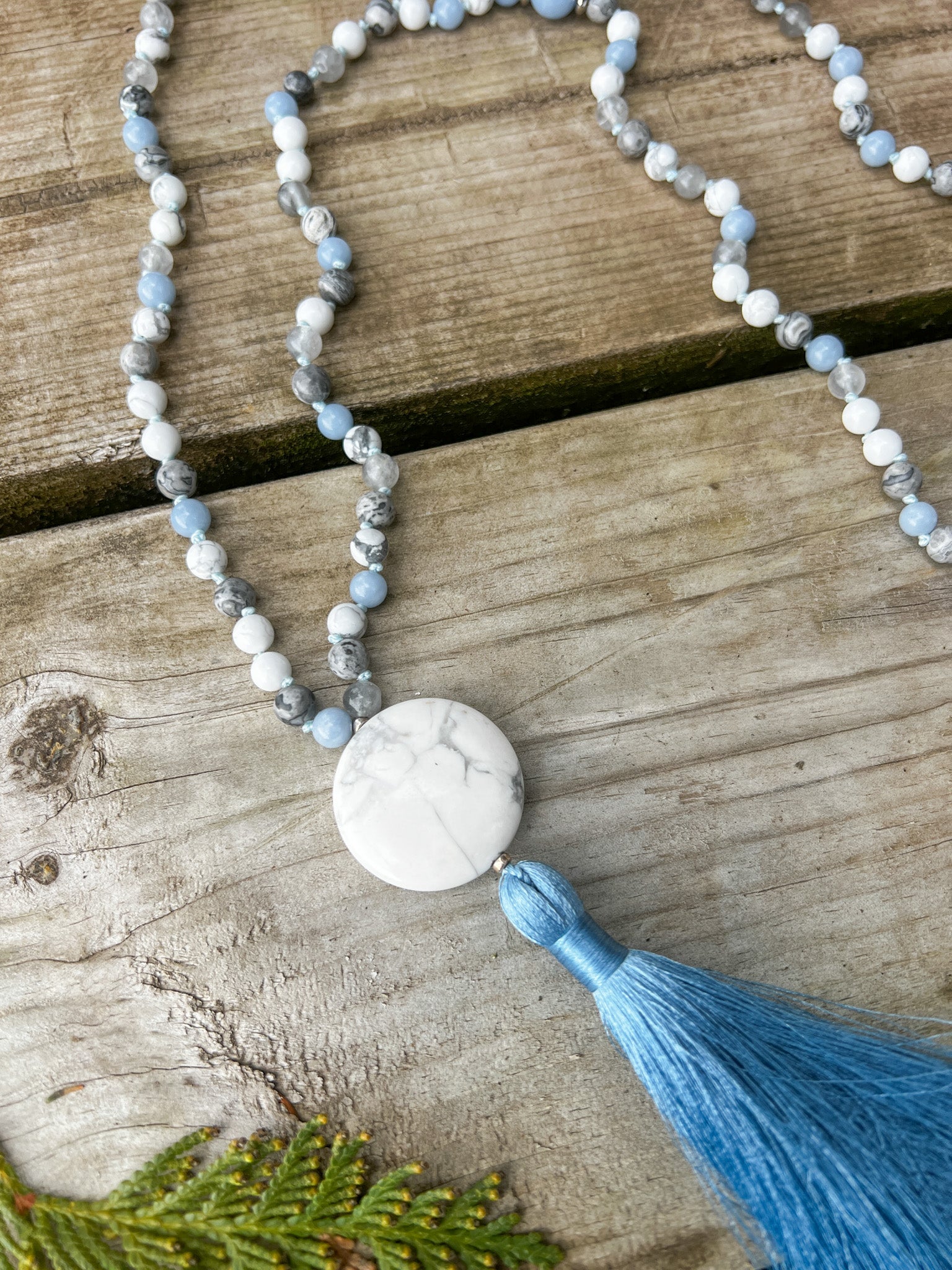 Close-up of the Open Sky Mala Necklace showing the round Howlite guru stone and silky sky blue tassel.