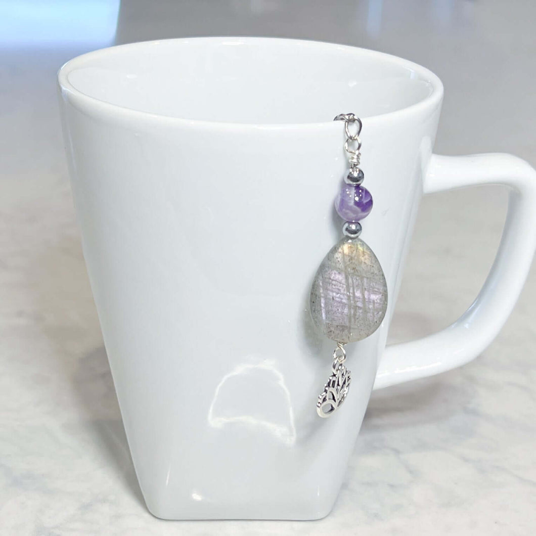 Amethyst and Labradorite Tea Strainer This tea strainer is made with a stainless steel tea ball, Chevron Amethyst, Labradorite, and Hematite beads. These stones offer clarity, transformation, and protection to the user.