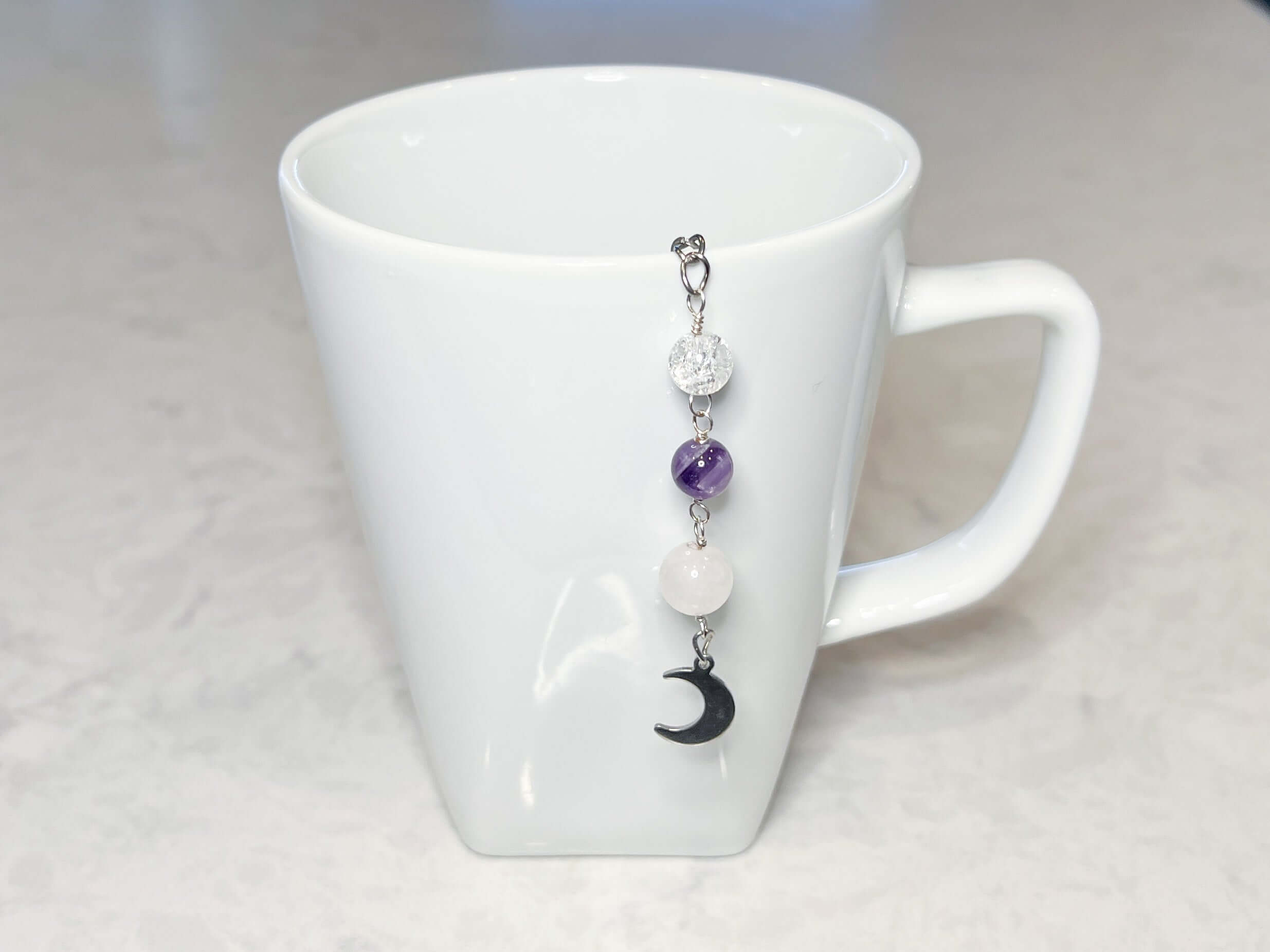 Amethyst and Quartz Tea Strainer This tea strainer is made with a stainless steel tea ball, Rose Quartz, Crystal Crackle Quartz, and Amethyst beads. These stones together bring the user mental clarity and universal love.