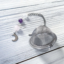 Load image into Gallery viewer, Amethyst and Quartz Tea Strainer This tea strainer is made with a stainless steel tea ball, Rose Quartz, Crystal Crackle Quartz, and Amethyst beads. These stones together bring the user mental clarity and universal love.
